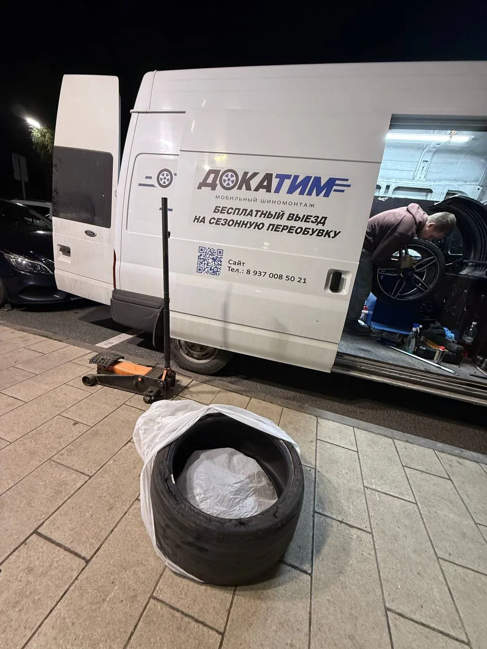 Фирменный Ford Transit ДОКАТИМ: мастер обслуживает колесо внутри мобильной мастерской