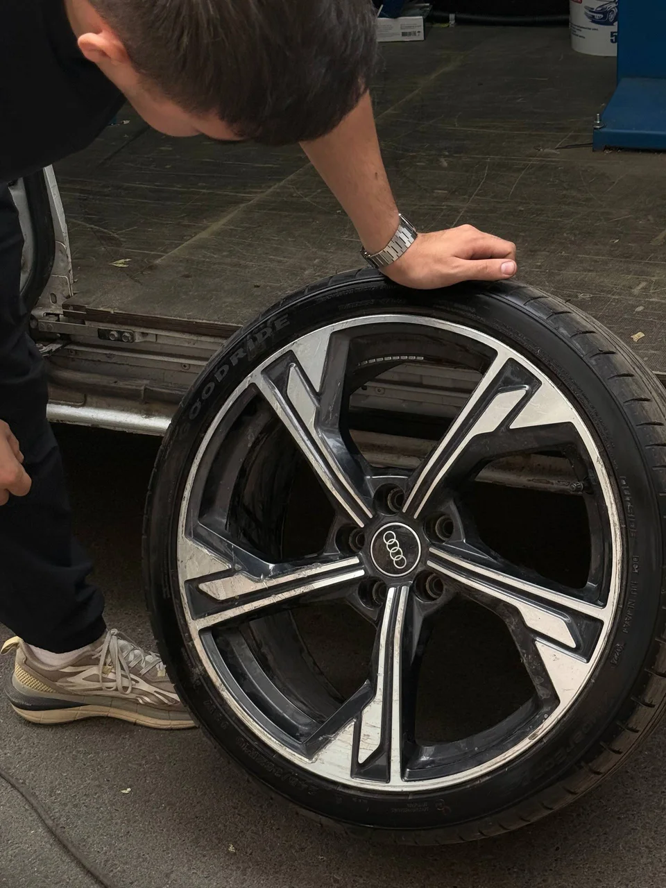 Мастер ДОКАТИМ осматривает шину на колесе Audi у мобильной мастерской